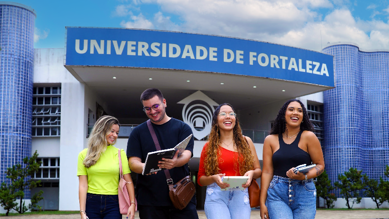 Jovens sorriem em frente ao Centro de Convivências