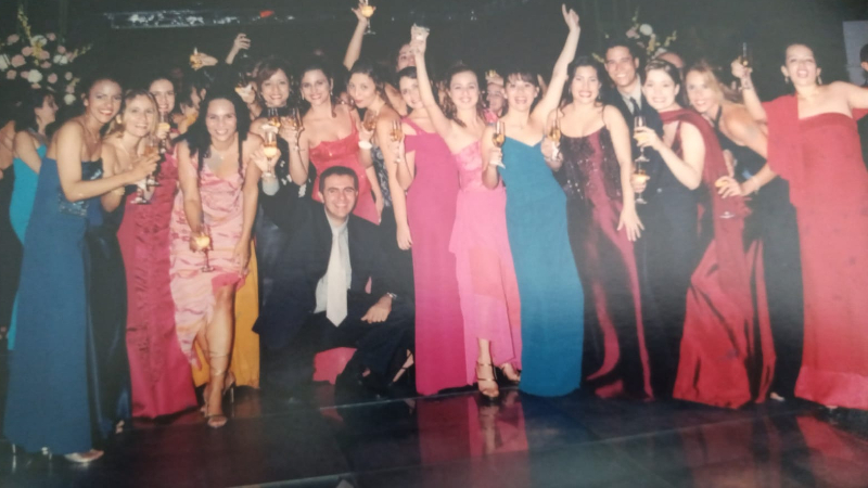 Na foto, os egressos do curso de Psicologia da Unifor durante a festa de formatura nos anos 2000. Eles voltaram a se reunir em frente à placa da turma, localizada no jardim ao lado do Bloco N  (Foto: Arquivo pessoal)