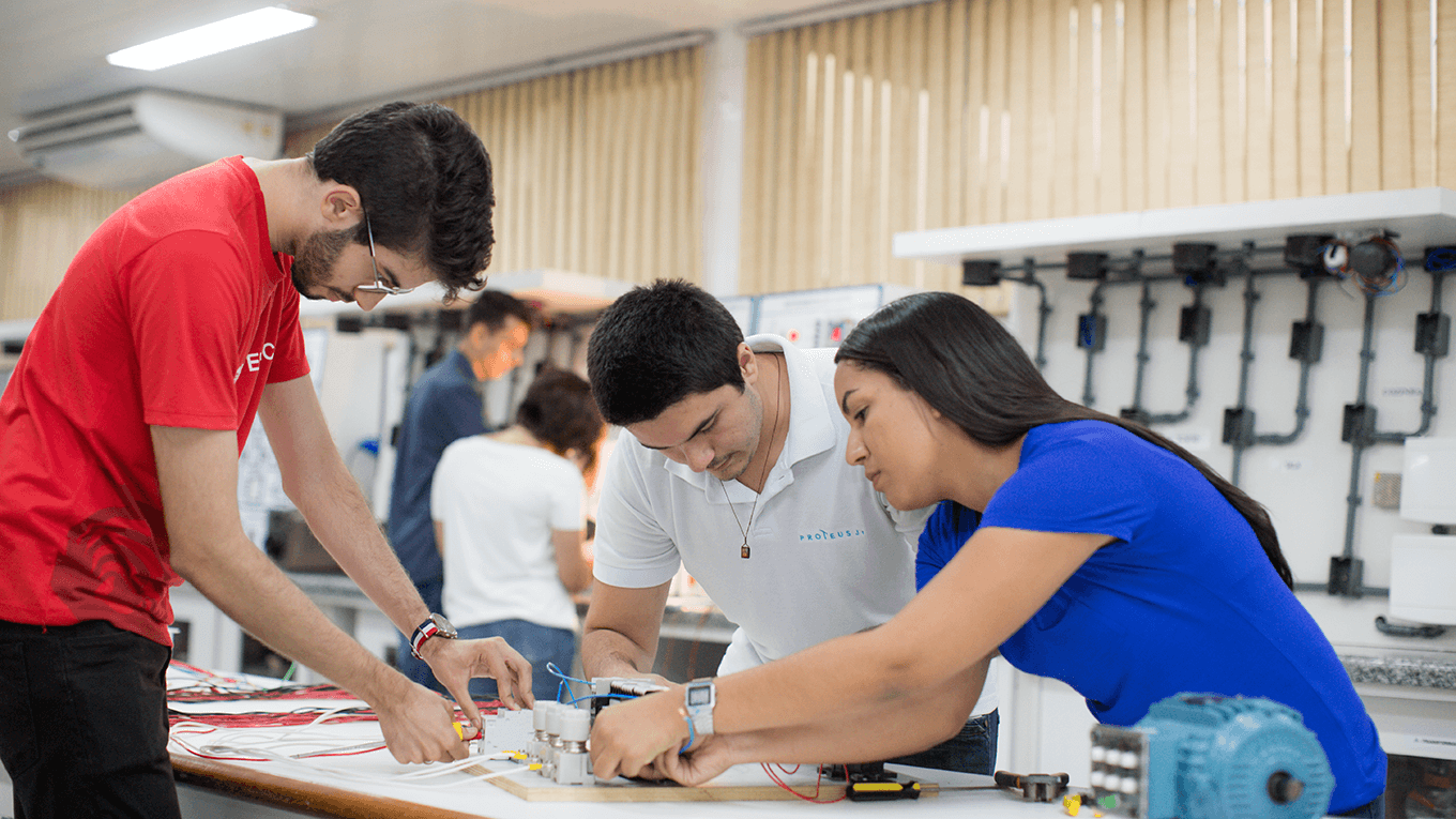 Estudantes manipulam maquete de instalação elétrica