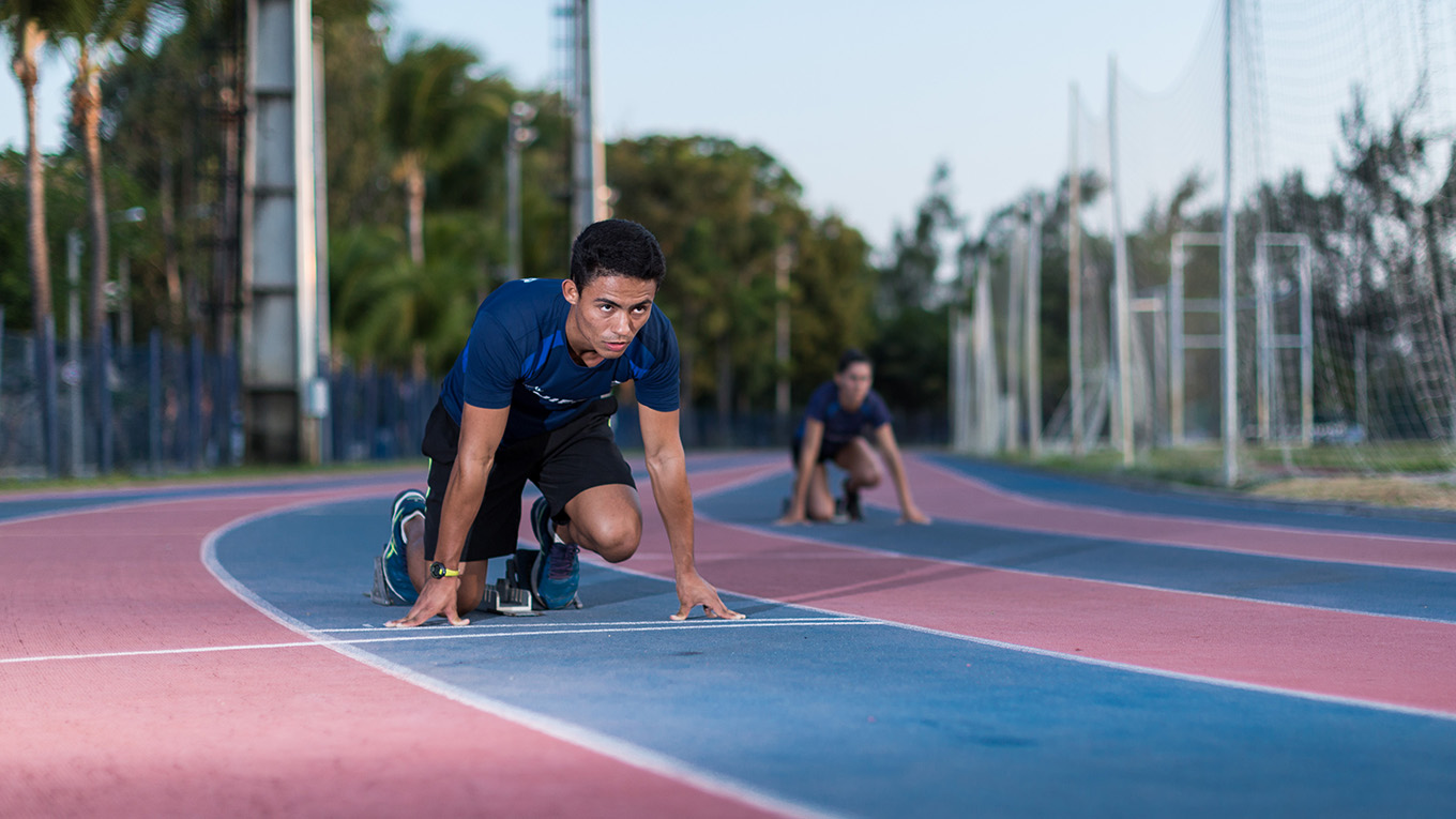 Estudante auxilia jovem a executar exercício