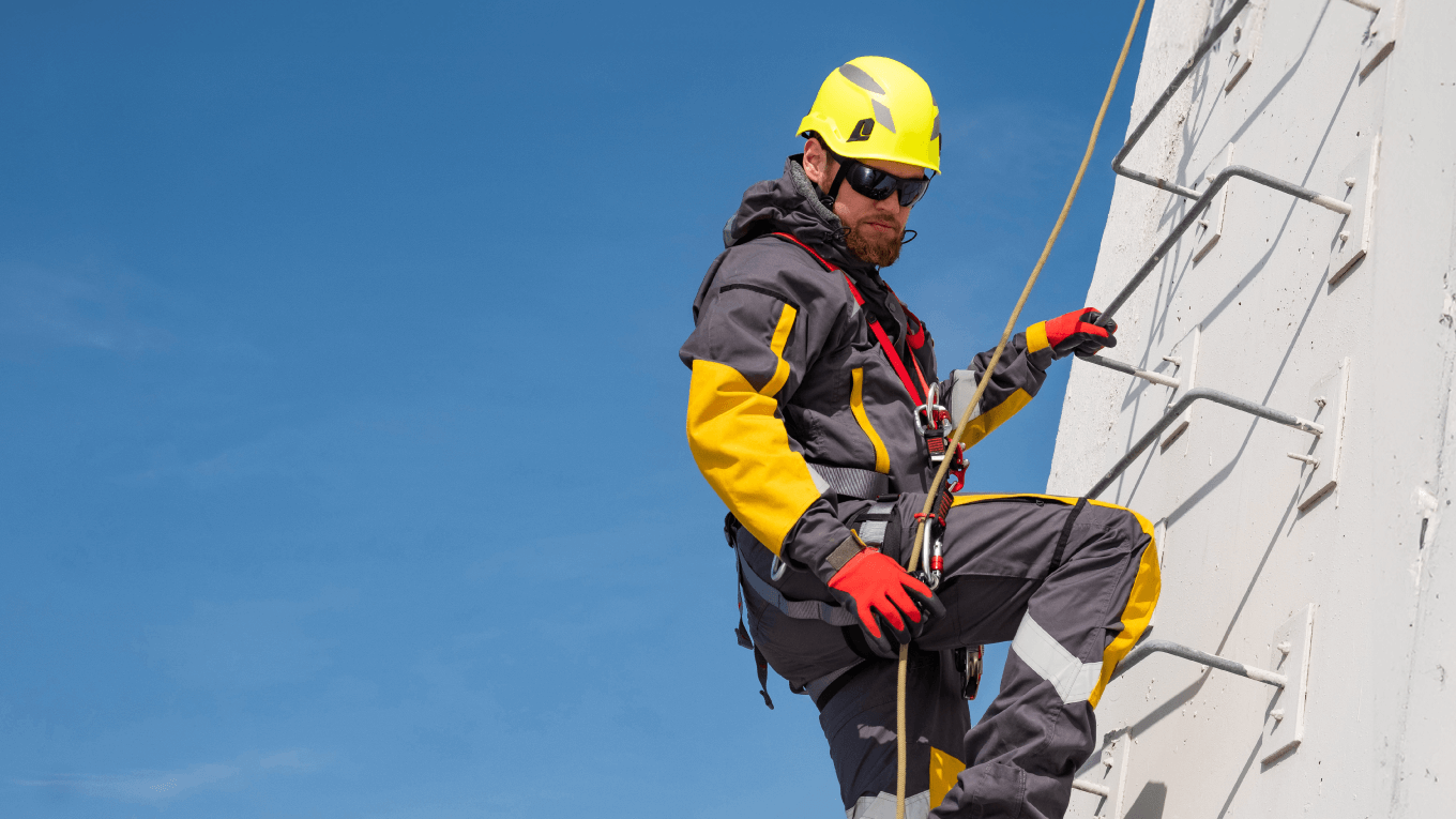 Trabalhador, devidamente equipado com EPIs, escala estrutura de concreto