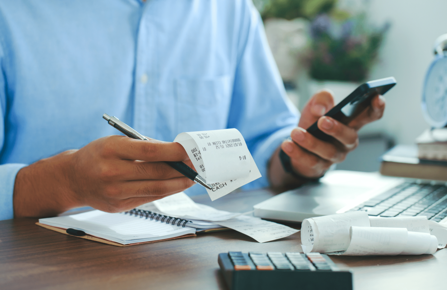 Homem usando smartphone e segurando contas verificando o custo no home office, comece a contar o sistema financeiro