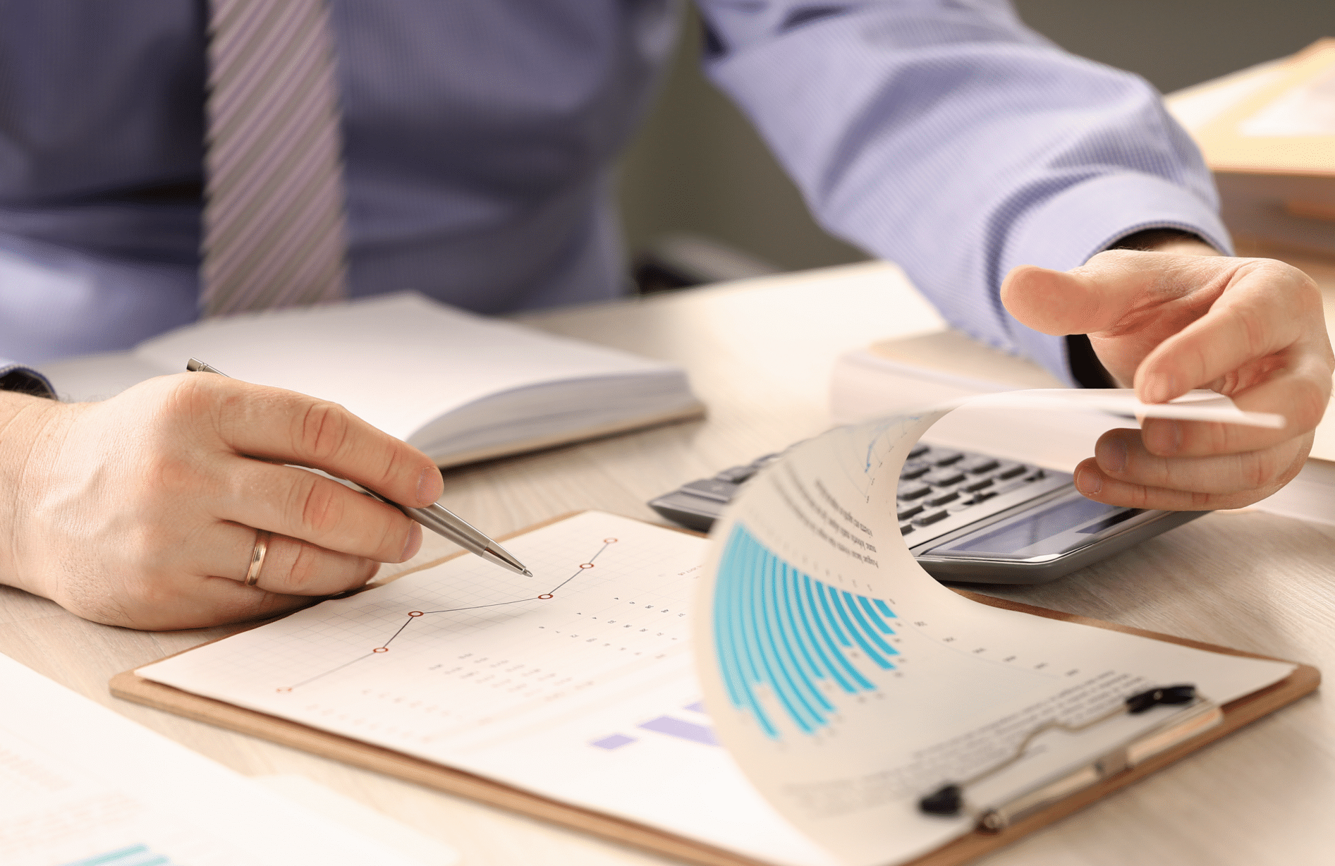 Inspetor financeiro calculando saldo, com um prancheta, uma calculadora e um caderno em uma mesa