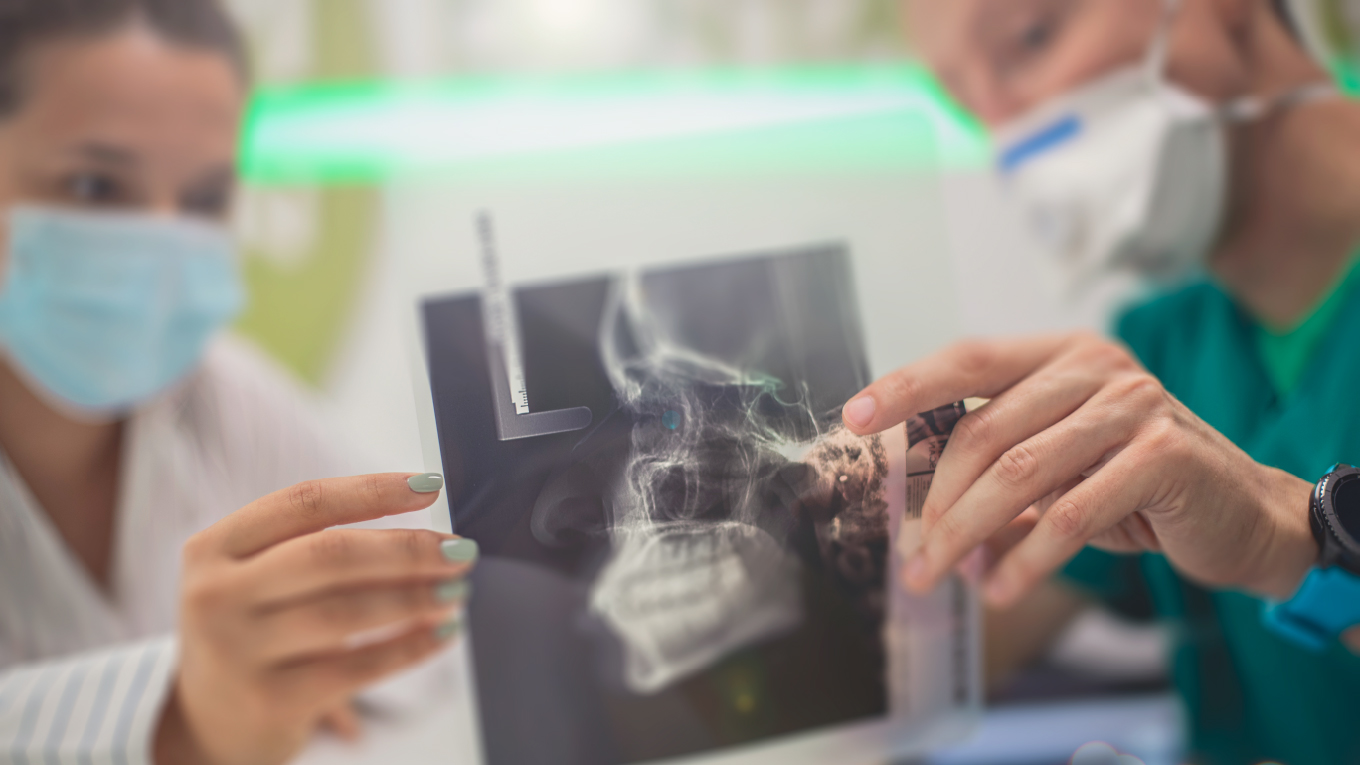 Dentistas segurando imagem de raio-x